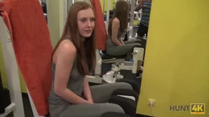 A young red-haired woman at a gym gives an intense POV blowjob to a man with impressive endowment